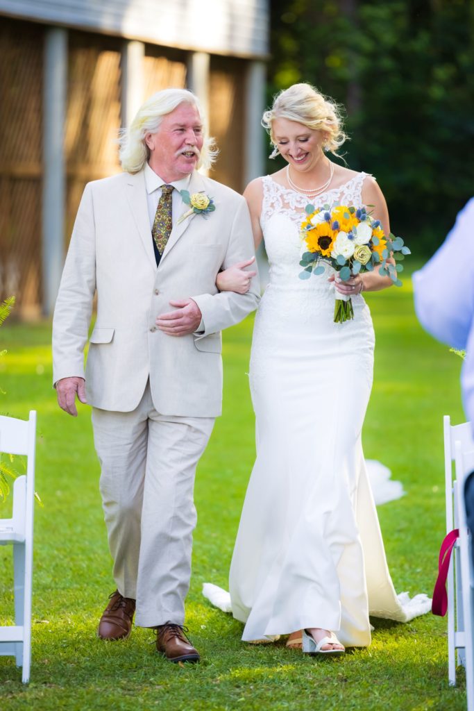 Bride's father walks her down the aisle at her Wando River Grill wedding in Charleston, South Carolina.