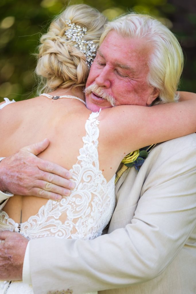 Father embraces daughter before Wando River Grill wedding ceremony in Charleston, South Carolina.